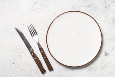 Beyaz zanaat tabak, çatal ve peçete beyaz taş masada. 