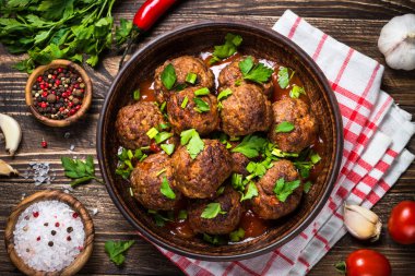 Ahşap masa üstüne domates soslu köfte görüntülemek. 