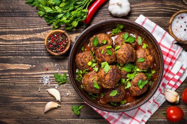 Ahşap masa üstüne domates soslu köfte görüntülemek. 