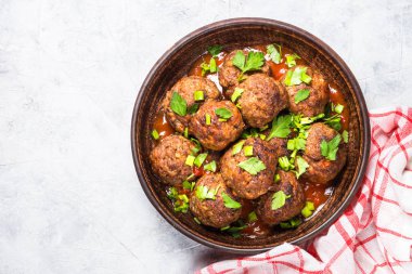 Işık üzerinde domates soslu köfte taş masa üstü görünümü. 