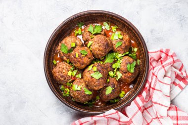 Işık üzerinde domates soslu köfte taş masa üstü görünümü. 