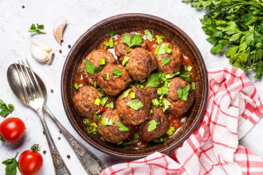 Işık üzerinde domates soslu köfte taş masa üstü görünümü. 