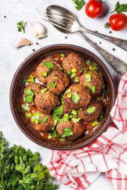 Işık üzerinde domates soslu köfte taş masa üstü görünümü. 