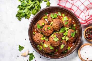 Işık üzerinde domates soslu köfte taş masa üstü görünümü. 