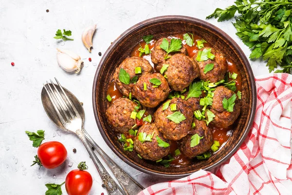 Işık üzerinde domates soslu köfte taş masa üstü görünümü. 