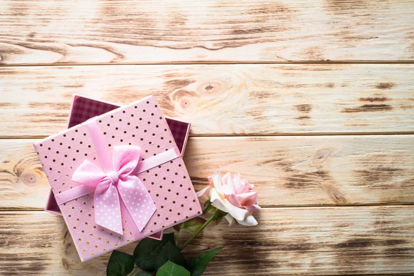 Present box and flower on wooden table. — Stock Photo, Image