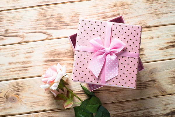 Present box and flower on wooden table. — Stock Photo, Image