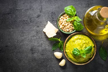 Pesto sos karanlık taş masada malzemelerle. 