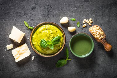 Pesto sos karanlık taş masada malzemelerle. 
