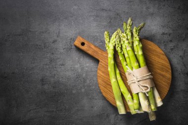 Siyah arduvaz arka plan üzerine taze yeşil kuşkonmaz.