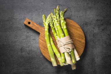 Siyah arduvaz arka plan üzerine taze yeşil kuşkonmaz.