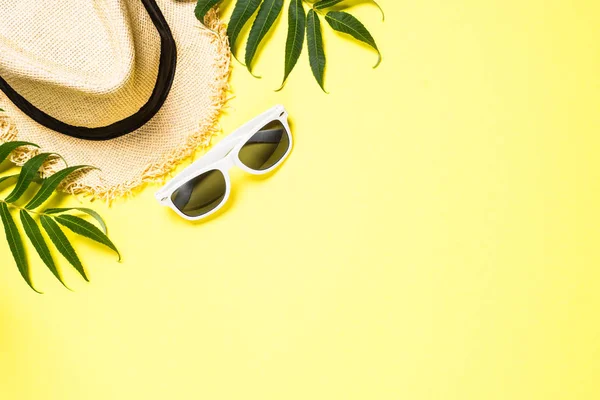 Summer hat and sunglasses on yellow top view. — Stock Photo, Image