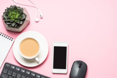 Not defteri, kahve fincanı ve pembe bir arka plan üzerinde klavye ile Ofis İşyeri.