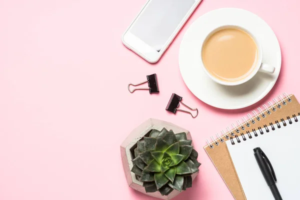 Blocco note vuoto, smartphone e cactus sulla vista dall'alto rosa . — Foto Stock