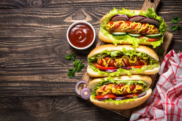 stock image Hot dog with fresh vegetables on wooden table.