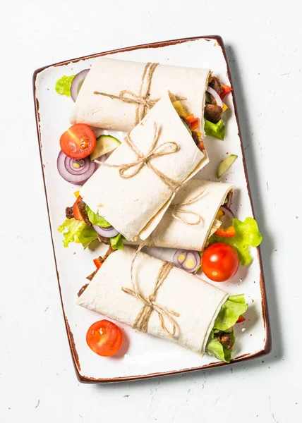 Burritos tortilla wraps med nötkött och grönsaker på vit bakgrund. — Stockfoto