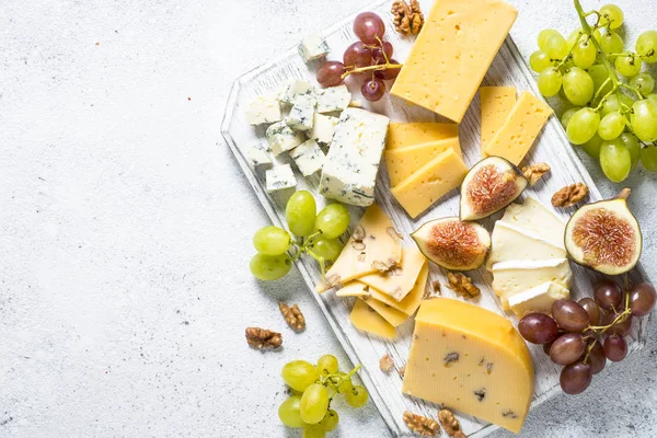 Cheese plate with grapes, figs and nuts. — Stock Photo, Image