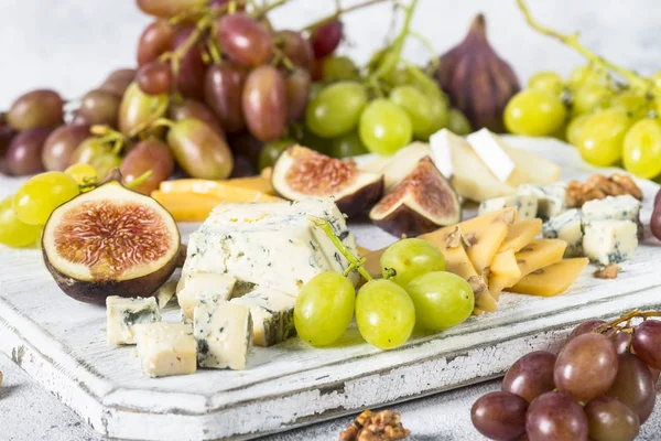 Сырная тарелка с виноградом, инжиром и орехами . — стоковое фото