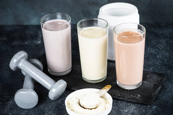 Protein drinkar och hantlar, sport och fitness koncept. — Stockfoto