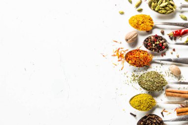 Beyaz üzerine kaşık içinde çeşitli baharatlar kümesi