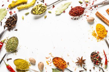 Beyaz üzerine kaşık içinde çeşitli baharatlar kümesi