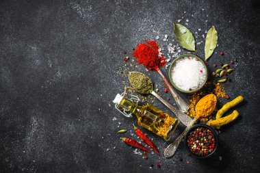 Baharat ve siyah taş zemin üzerine zeytin yağı.