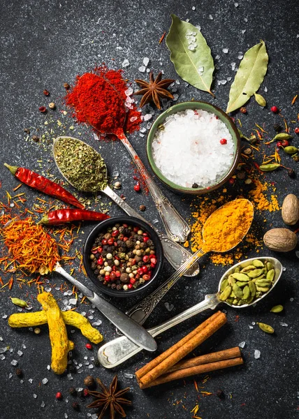 Set of various spices  on black stone background.