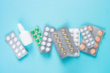 Tabletler ve ilaçlar üzerinde mavi bir arka plan.