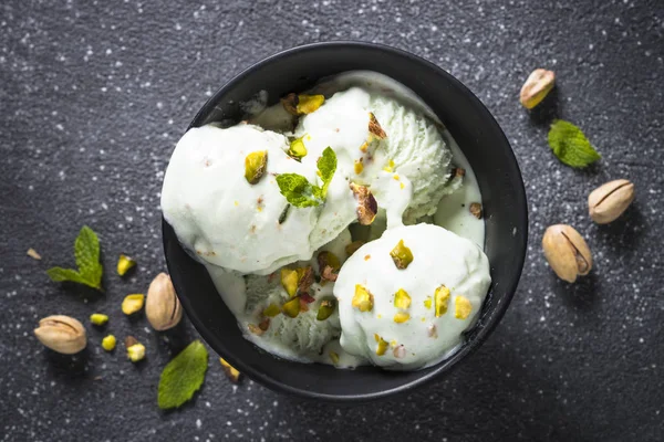 Pistazien-Eis in Schüssel auf schwarzem Stein-Tisch. — Stockfoto