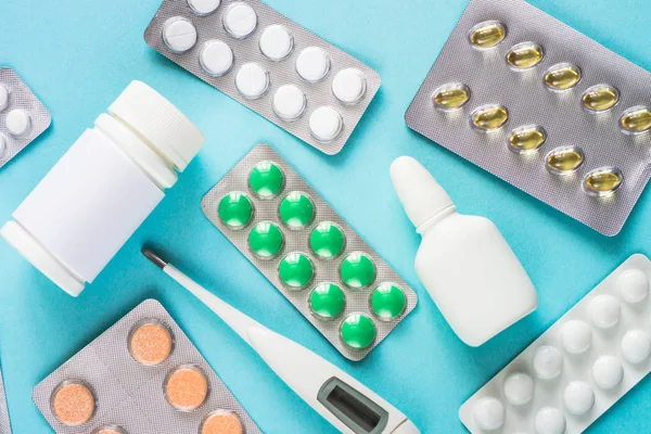 Tabletták és gyógyszerek, kék háttérrel. — Stock Fotó