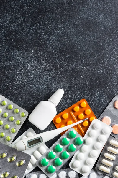 Tabletas y medicamentos en una vista superior negra . — Foto de Stock