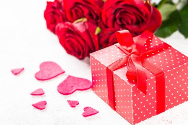 Sevgiliye arka plan. Kırmızı gül, kalp, beyaz hediye.