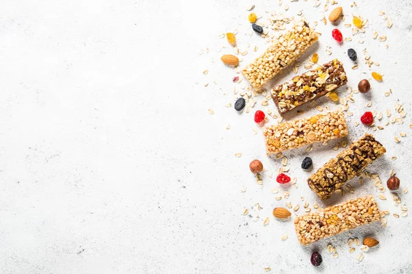 Granola bar with nuts, fruit and berries on white.