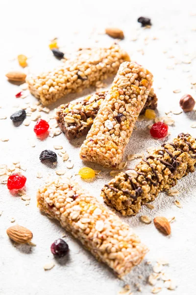 Granola bar with nuts, fruit and berries on white.