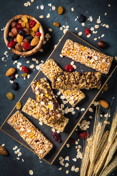 Granola bar with nuts, fruit and berries on black. — Stock Photo, Image