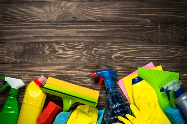 Cleaning product, household, sanitary supplies on wooden table. Top view with copy space.