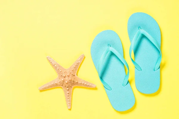 Blå flip flops och sjöstjärnor på gul bakgrund. — Stockfoto