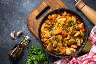 Tavuk güveç sebze siyah taş tabloyla, üstten görünüm.