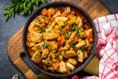 Tavuk güveç sebze siyah taş tabloyla, üstten görünüm.