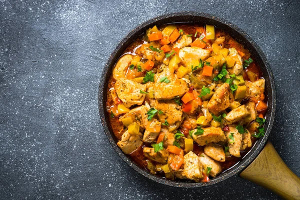 Chicken stew with vegetables black stone table, top view. — Stock Photo, Image