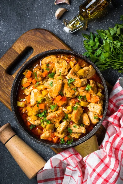 Tavuk güveç sebze siyah taş tabloyla, üstten görünüm.