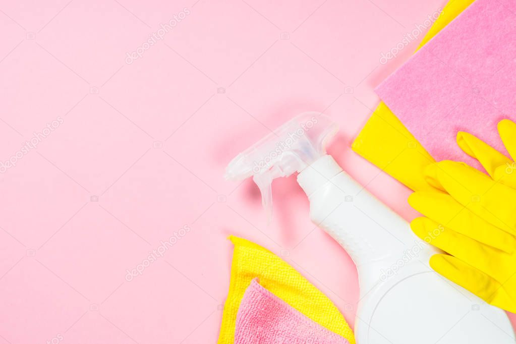 Cleaning spray, cloth and gloves on pink background.