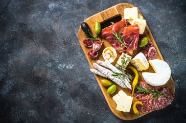 Meze kurulu dilimlenmiş et, jambon, salam, peynir, zeytin ve kırmızı şarap ile. 