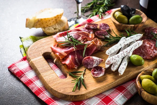 Antipasto salumi affettati, prosciutto, salumi, olive su tavola di legno . — Foto Stock