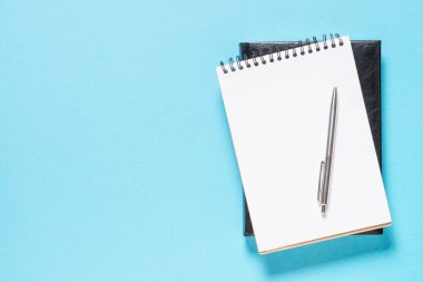 mavi arkaplanda dizüstü bilgisayar ve kalem.