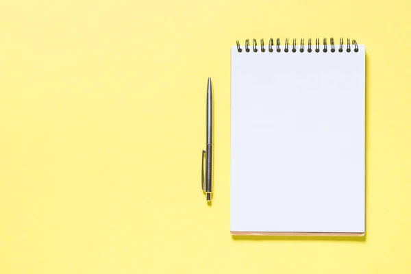 Notebook, pen and smartphone on yellow — Stock Photo, Image