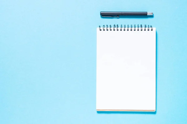 Cuaderno y pluma sobre fondo azul. —  Fotos de Stock