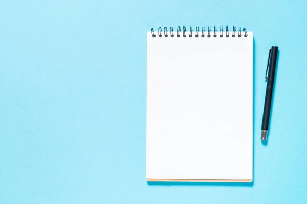 Cuaderno y pluma sobre fondo azul. —  Fotos de Stock