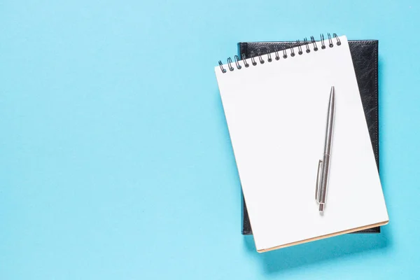 Cuaderno y pluma sobre fondo azul. —  Fotos de Stock