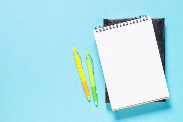 Notebook and pens on blue. Stock Image